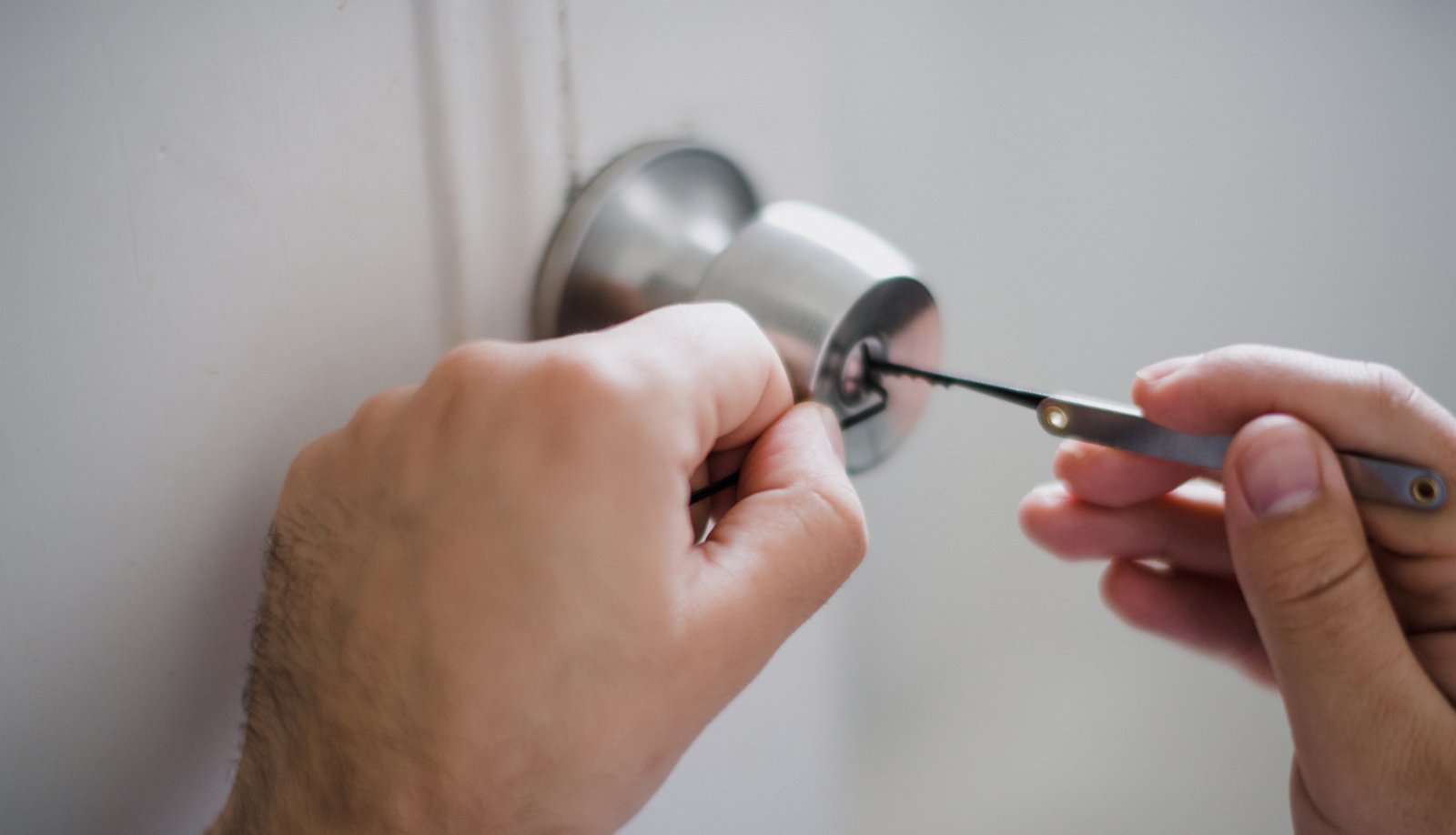 Keysmith technician repairing residential door lock with precision tools
