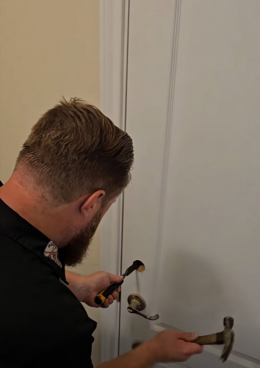 Professional locksmith from ReKey Xpress using specialized tools to open a locked front door during an emergency.