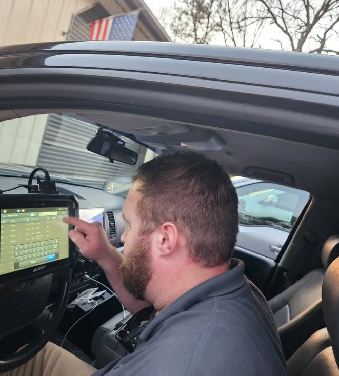 One man, locksmith cutting car key with his machine in workshop. Locksmith rekeying front door lock after new homeowner move-in in Montgomery neighborhood