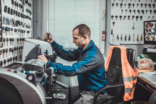 One man, locksmith cutting car key with his machine in workshop. ReKey Xpress Locksmith providing fast rekeying in Magnolia, TX