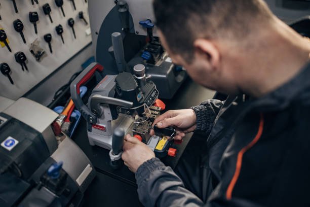 One man, professional key cutter, making car keys copies on modern machine. ReKey Xpress Locksmith rekeying a residential door lock in Willis, TX
